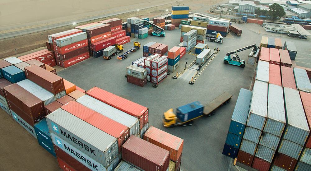 Full Container Depot with stacked containers and transport vehicles for efficient logistics.